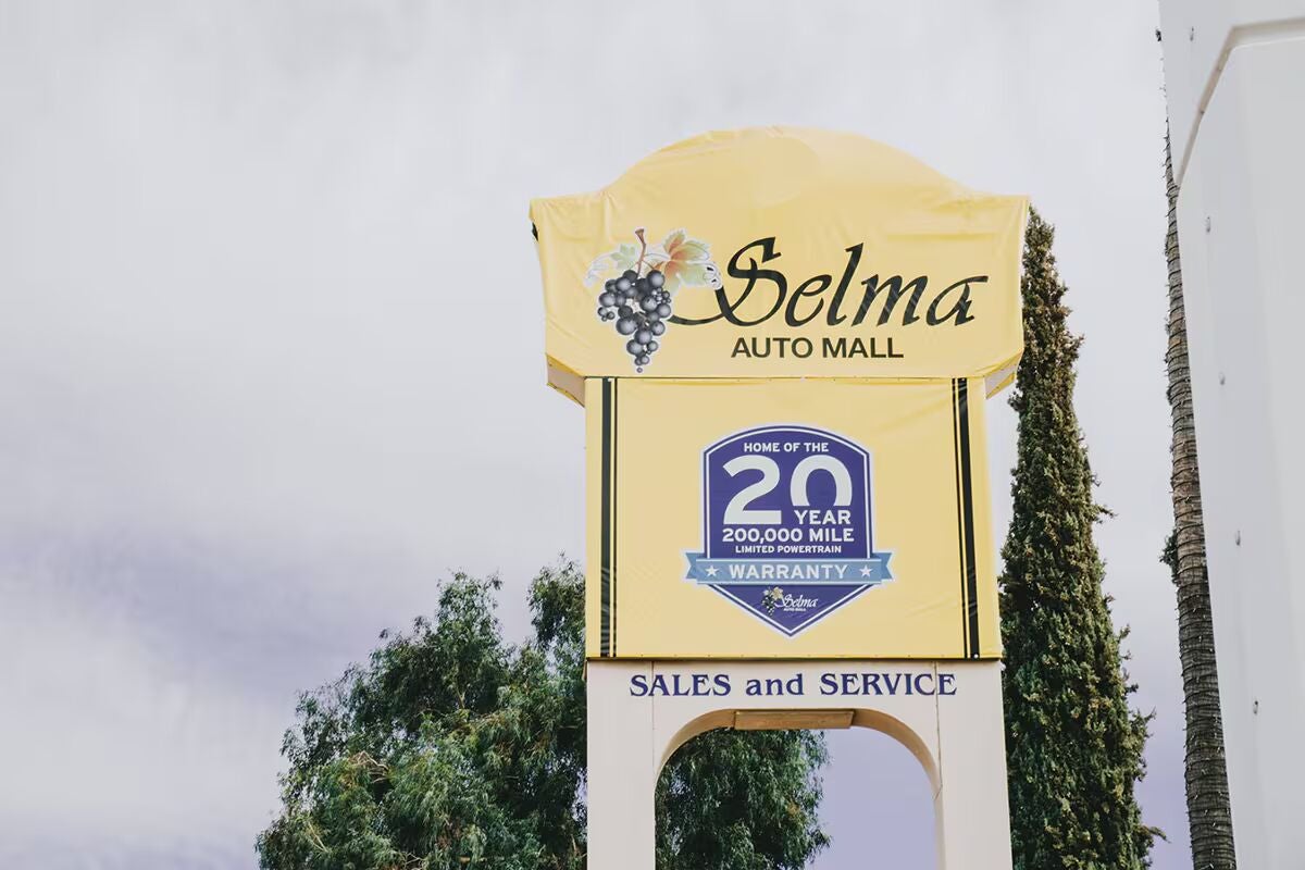 A yellow Selma Auto Mall sign with grape cluster logo.